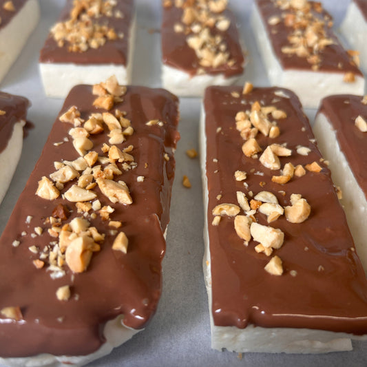 Snickers-inspired protein marshmallow with caramel flavour, milk chocolate and roasted peanuts, handmade in the UK with 9g protein and approximately 160 calories.