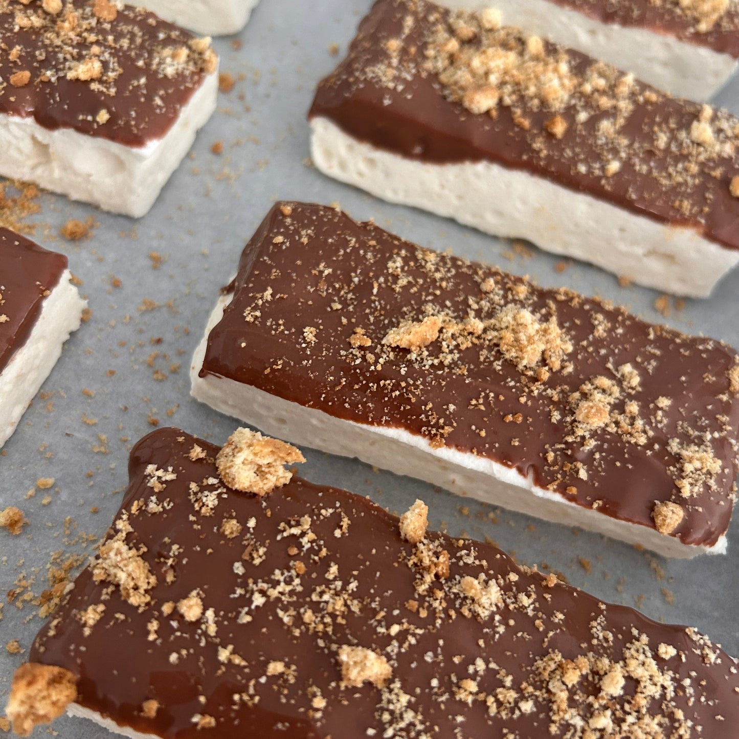 Banoffee Protein Marshmallow Bar coated in milk chocolate and topped with crushed digestive biscuit, handmade in the UK by Trim Treats.