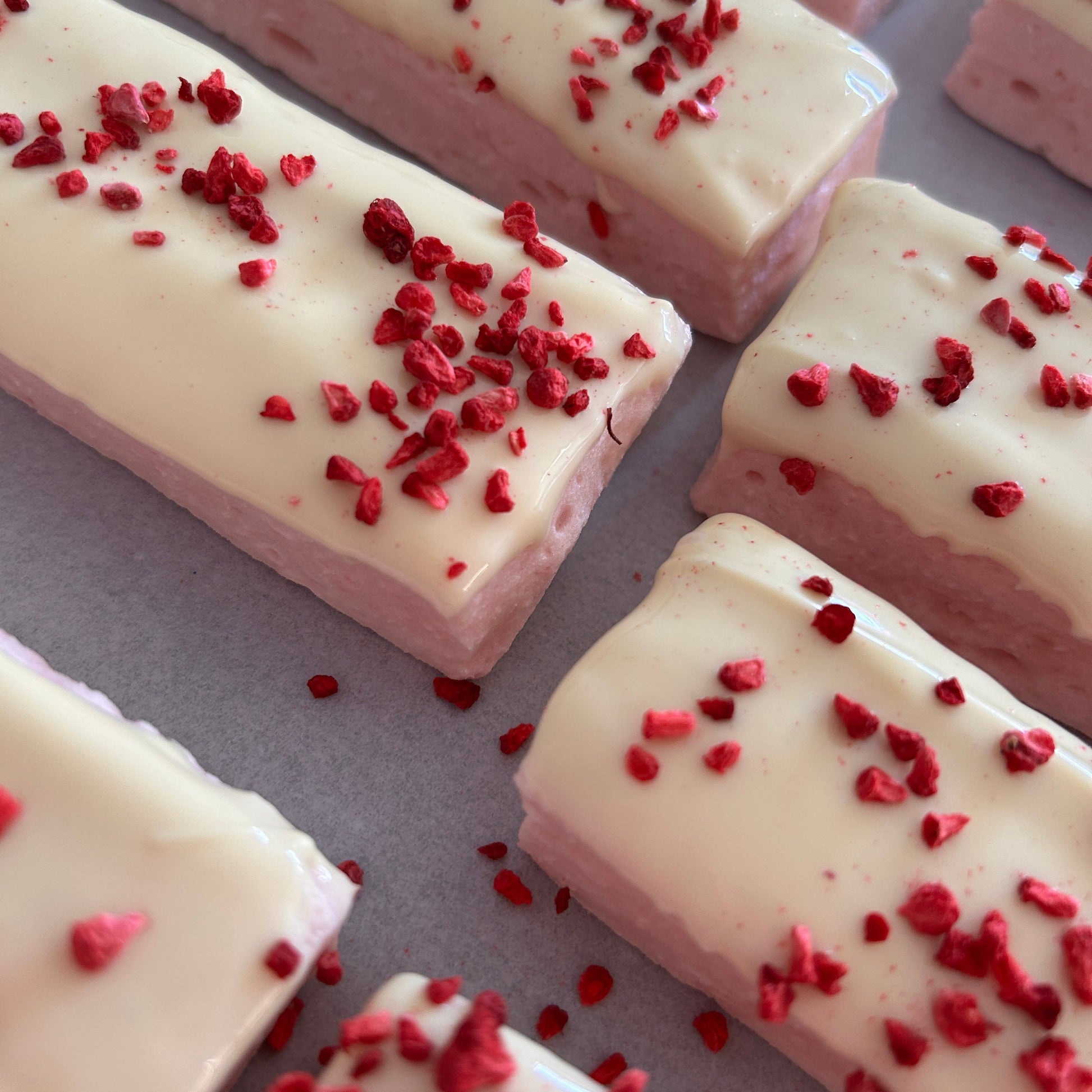 Low calorie raspberry and white chocolate protein marshmallow bars coated in white chocolate.