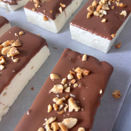 Snickers-inspired protein marshmallow with caramel flavour, milk chocolate and roasted peanuts, handmade in the UK with 9g protein and approximately 160 calories.